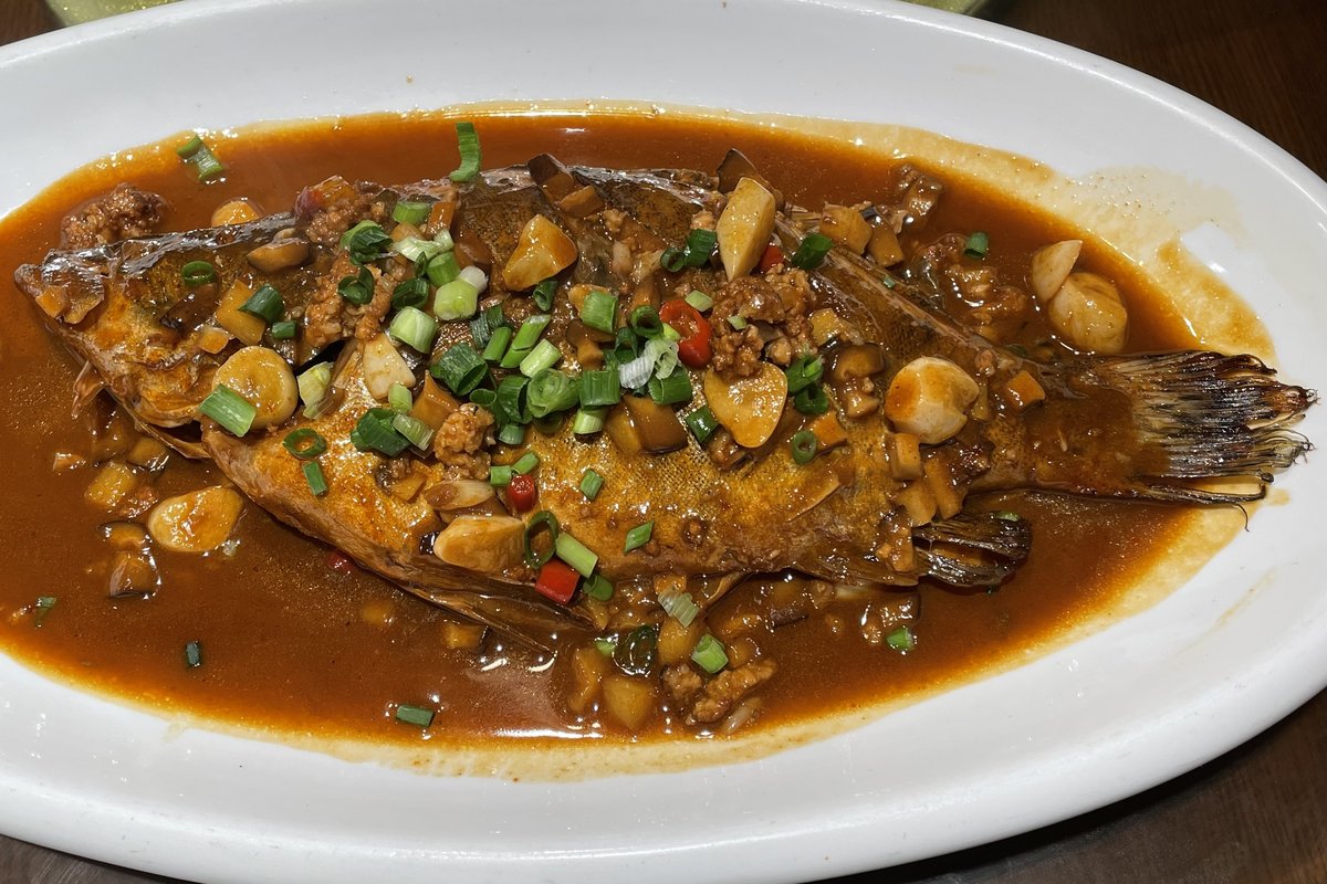 Anhui-style braised mandarin fish in rich brown sauce topped with spring onions, mushrooms and red chilli