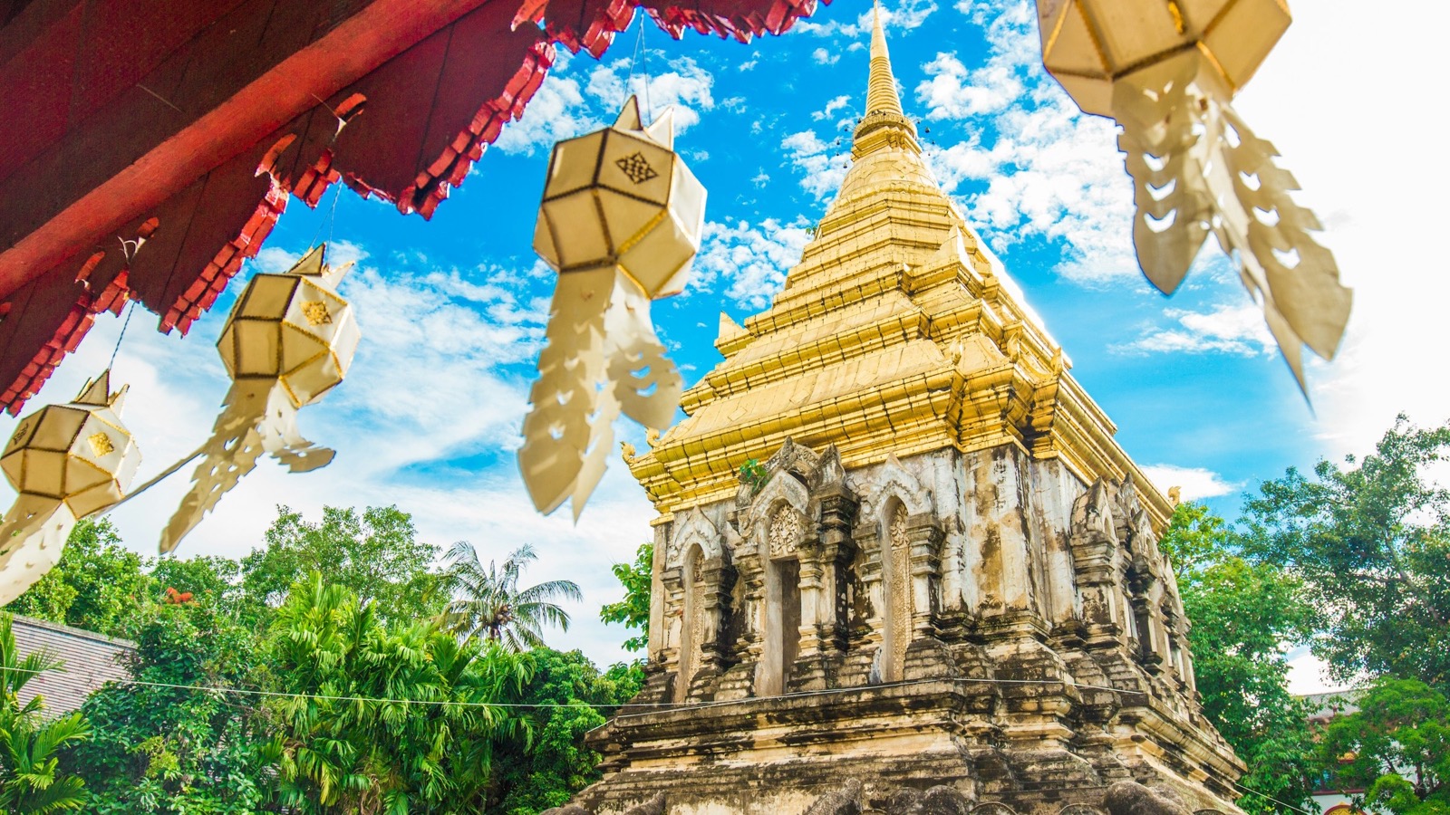 Golden Lanna chedi with traditional hanging tung lanterns at a Chiang Mai temple, northern Thailand — learn Mandarin online from Chiang Mai