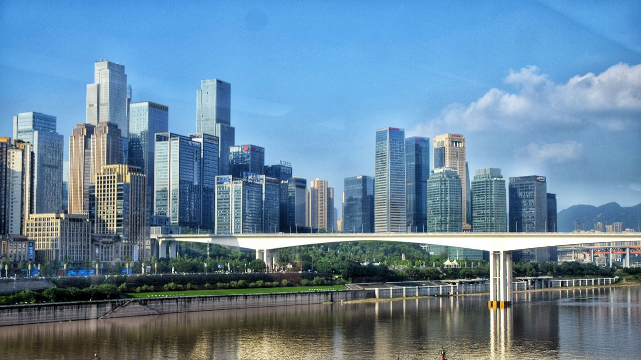 A bridge spanning the river between Chongqing&rsquo;s high-rise districts by day