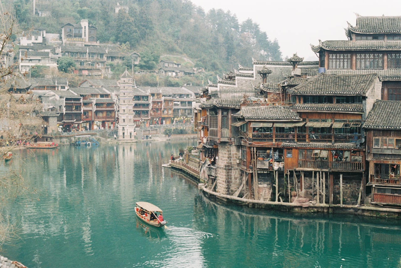 Wooden stilt houses and a boat on the river at Fenghuang ancient town, Hunan