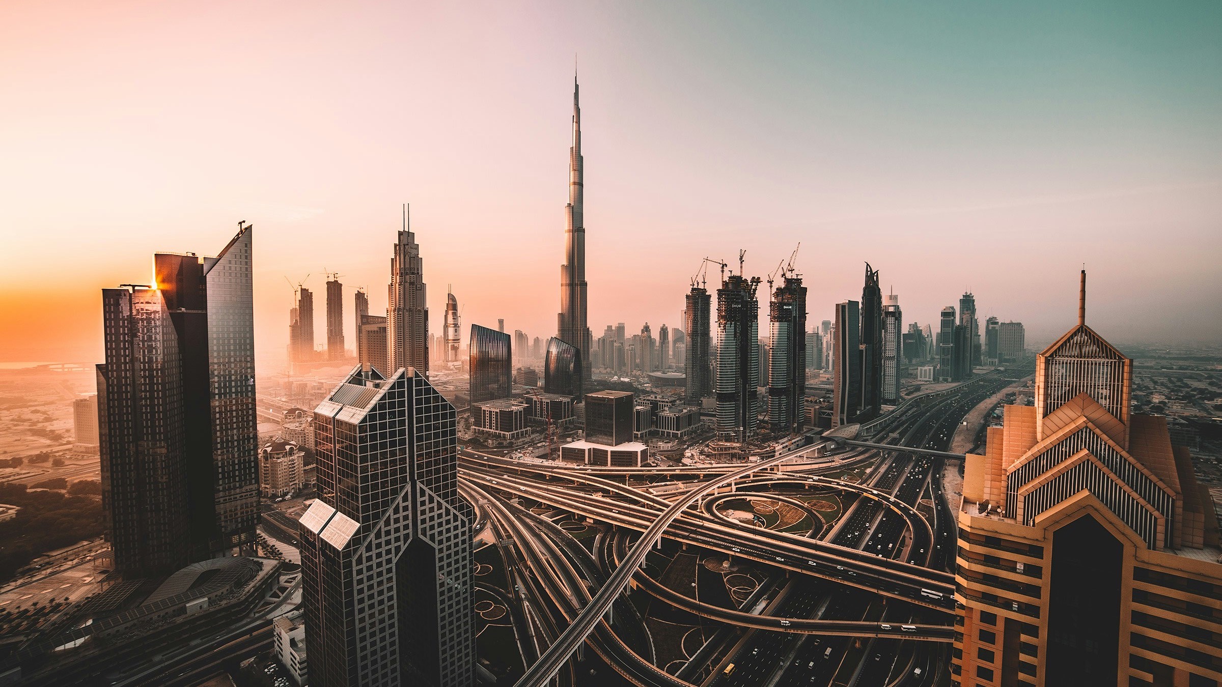 Downtown Dubai at sunrise — the Burj Khalifa above the Sheikh Zayed Road interchange, where WillyChina students learn Mandarin online from Dubai