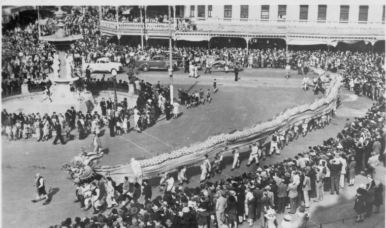 An aerial view of a long Chinese processional dragon coiling through a packed crowd at the Bendigo Easter Fair, in the early twentieth century.