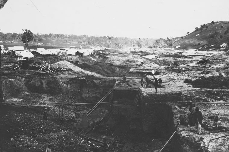 A Chinese goldmining camp near Guildford, Victoria, in 1861: worked-over ground, tents and timber huts along a creek under bare hills.