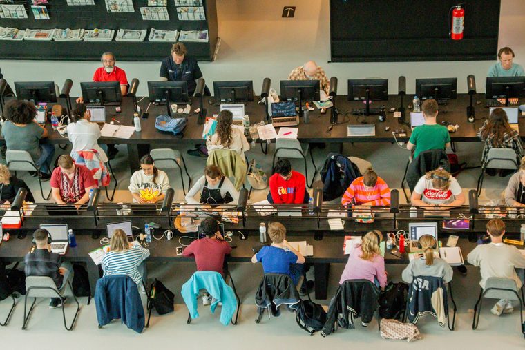 HSK test centres: rows of students working at long desks in a university study hall, seen from above.