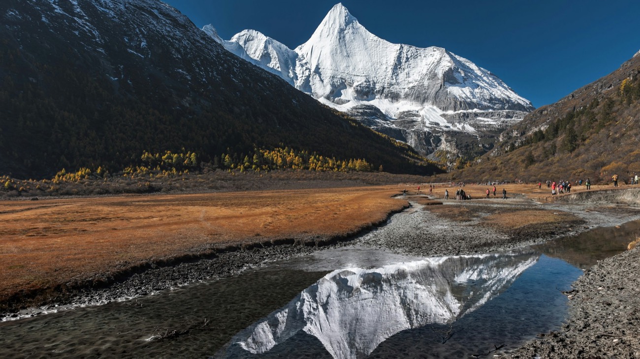 Jambeyang sacred peak with autumn meadow and stream reflection at Yading, Daocheng, Sichuan