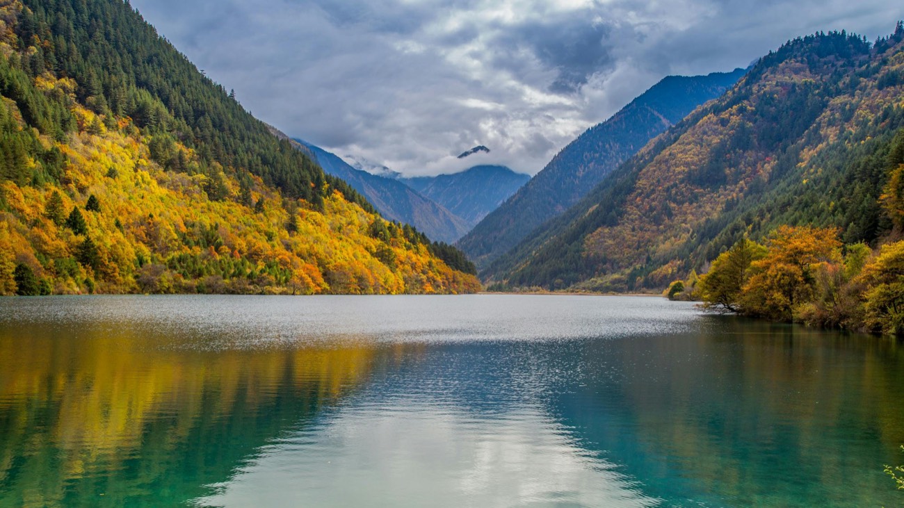 Jiuzhaigou Valley in autumn — UNESCO World Heritage with golden foliage reflected in turquoise lake, Sichuan