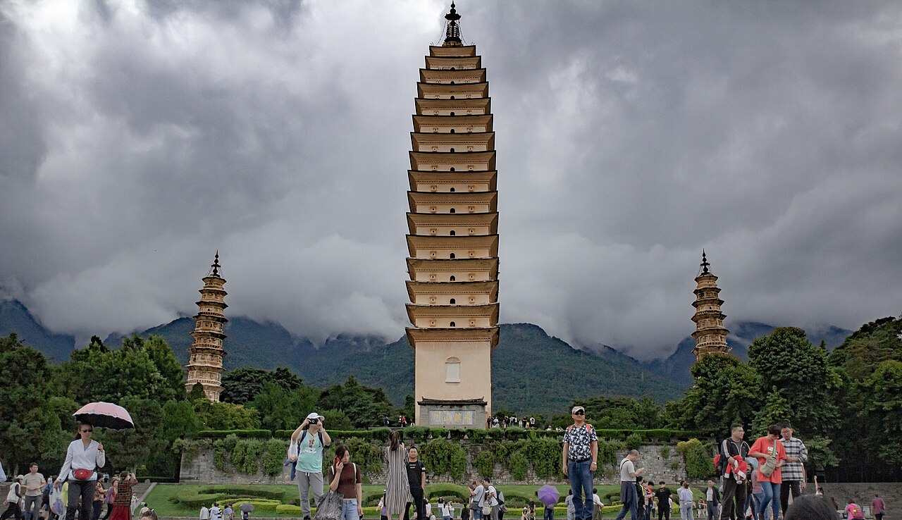The Three Pagodas of Chongsheng Temple reflected in a lake with Cangshan mountains behind, Dali, Yunnan