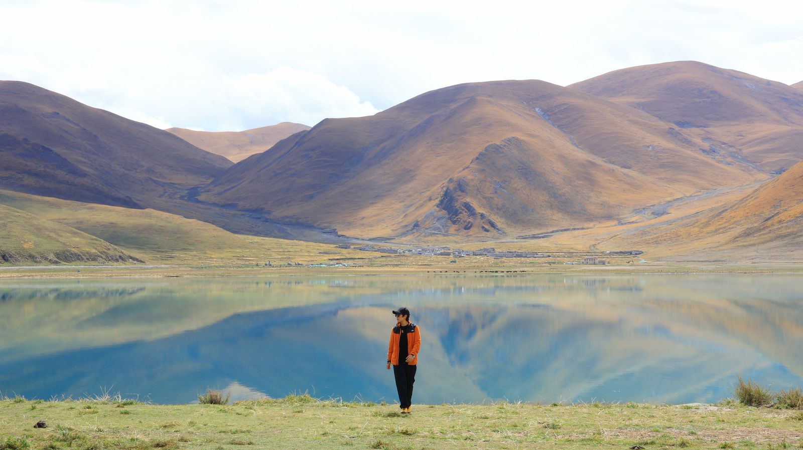 A still plateau lake reflecting golden hills near Shannan, Tibet