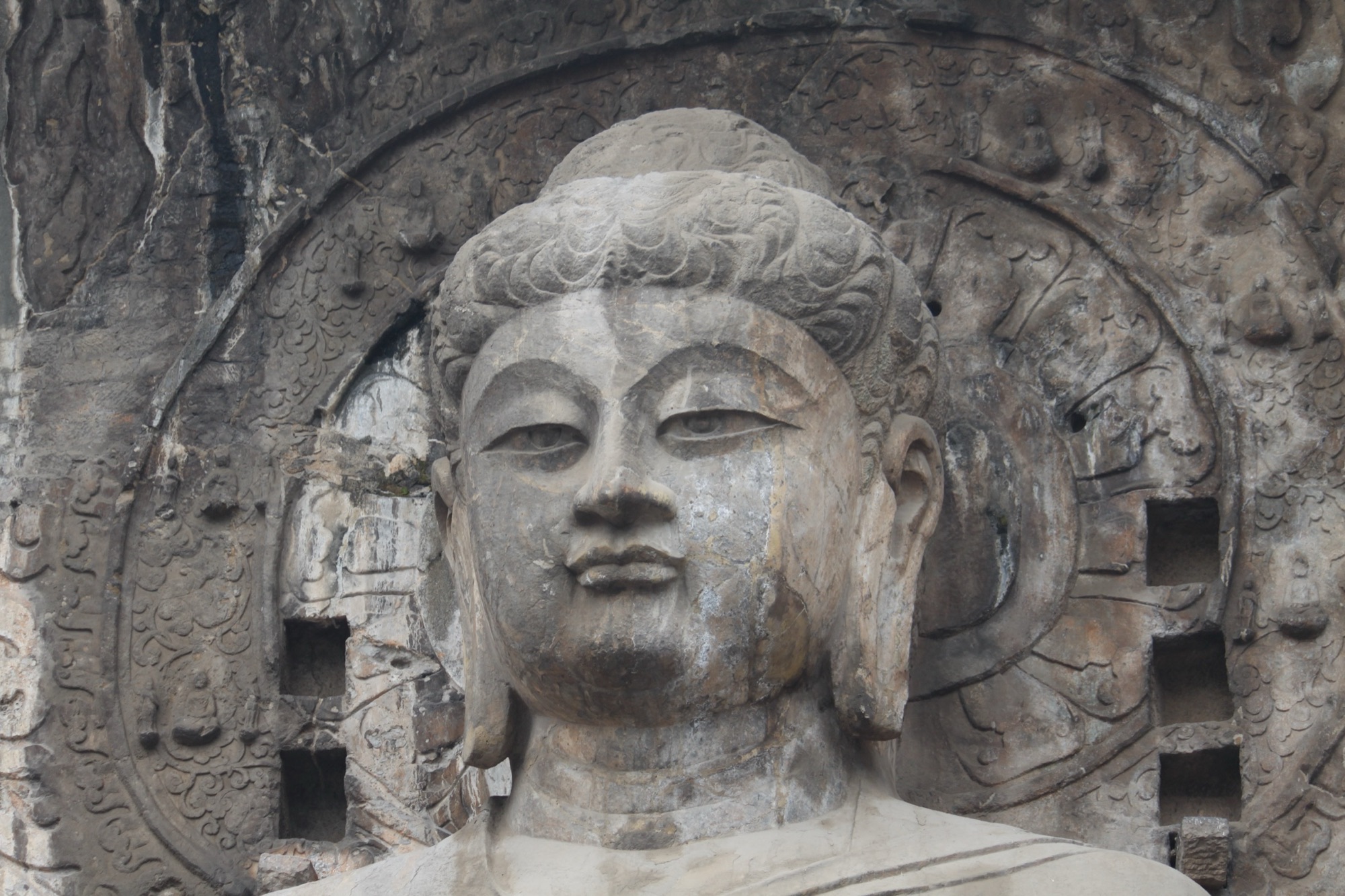 The colossal Vairocana Buddha carved into the cliff at the Longmen Grottoes, Luoyang, Henan