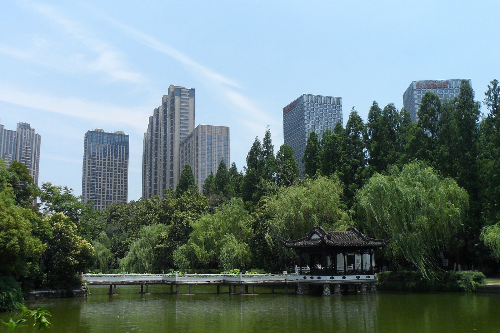 A pavilion on the water in Lord Bao Park, Hefei, with the city’s skyline behind