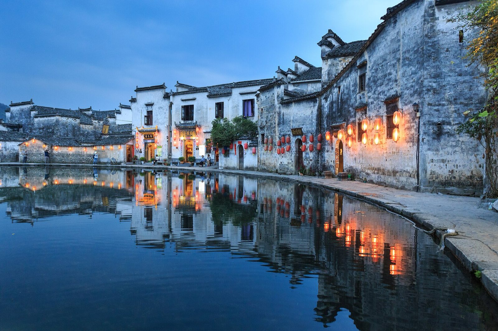 Hongcun village near Huangshan at dusk, its white houses and red lanterns reflected in the Moon Pond